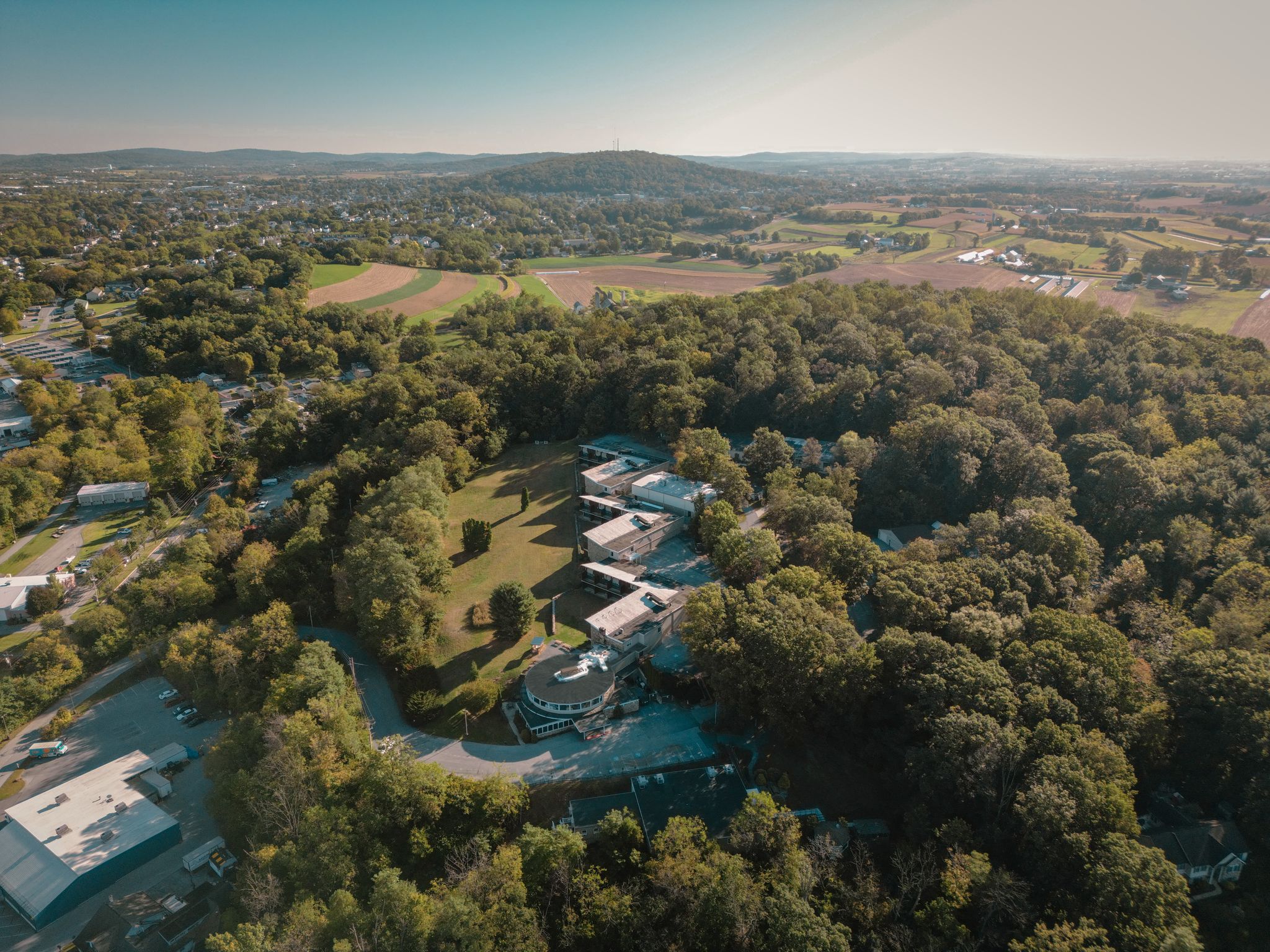 Aerial view of a behavioral health treatment facility surrounded by trees and open land.