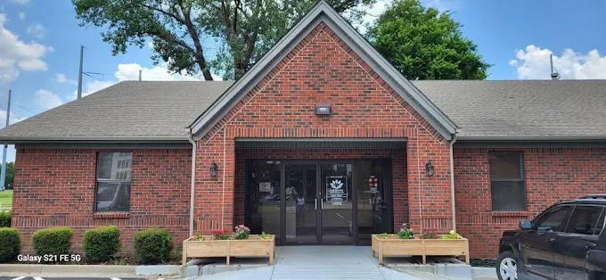 Brick building with glass doors and planters at main entrance