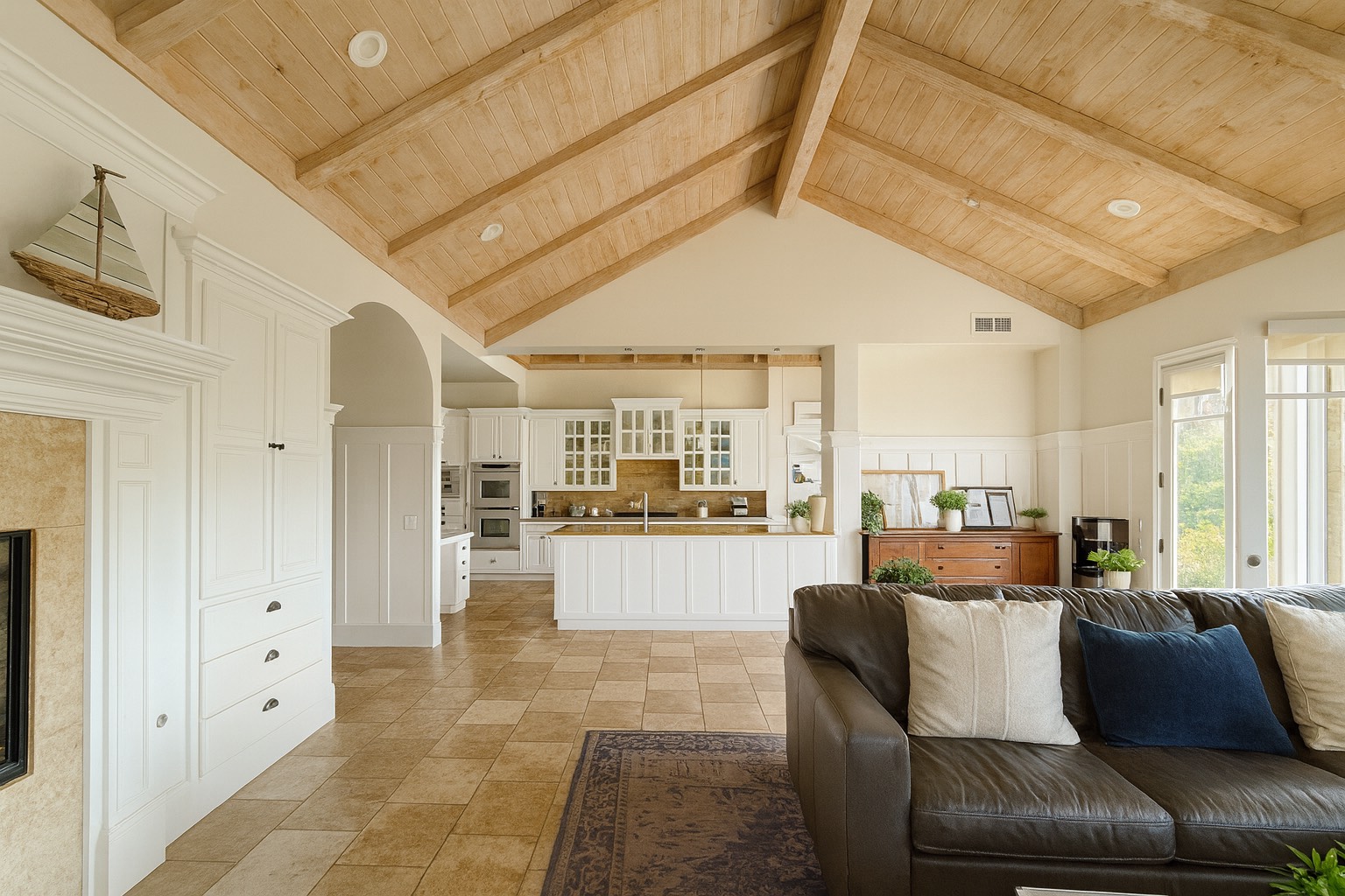 Open living space with vaulted wood ceiling and full modern kitchen.