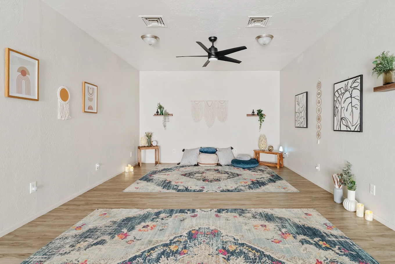 Shared bedroom with two beds, rugs, and wall decor