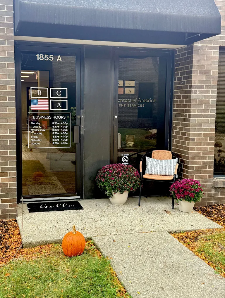 Outpatient center entrance with glass door and potted flowers