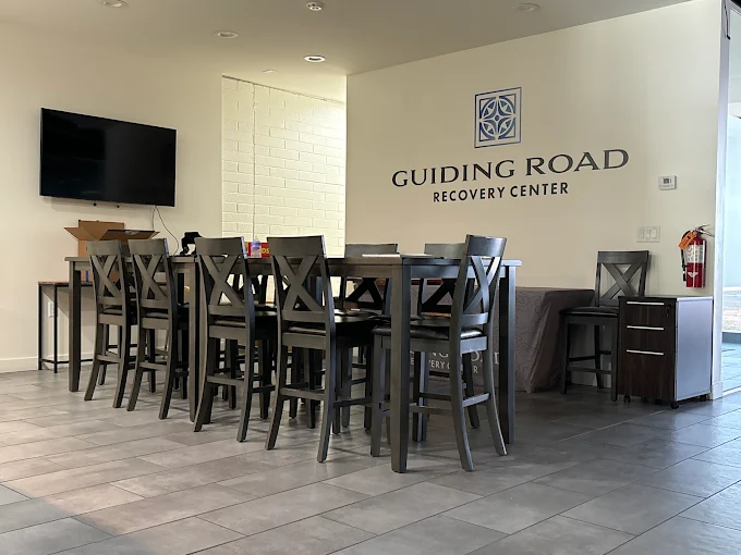 Dining area with tall black chairs and wall logo