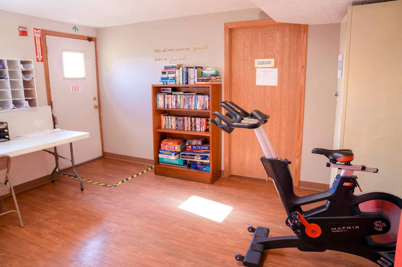 Recreation room with exercise bike and bookshelf