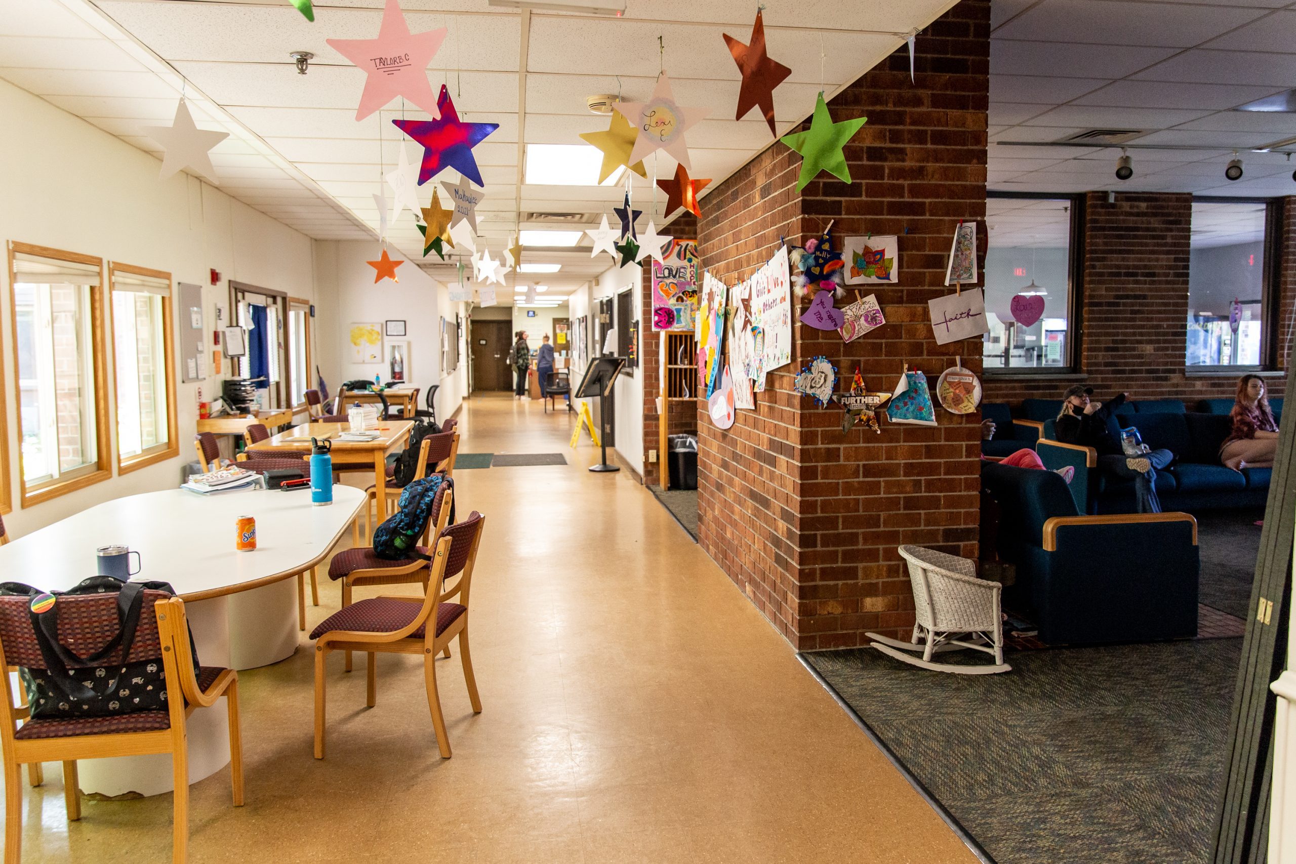 Community lounge with tables, art wall, and hanging stars