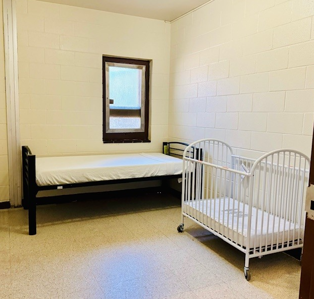 Bedroom with single bed and white crib