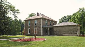 Stone Lodge exterior with large yard and trees