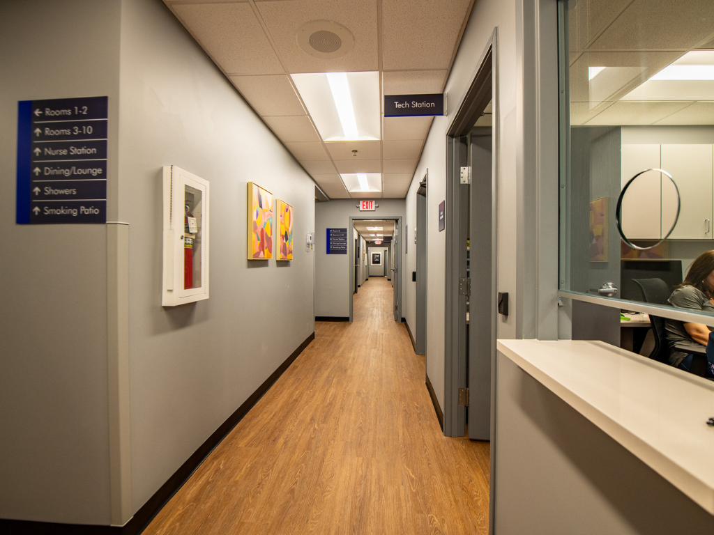 Interior hallway with signs, rooms, and reception window