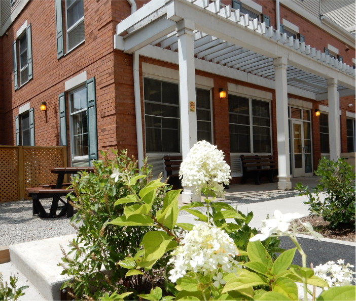 Brick rehab facility with covered entrance and outdoor seating area