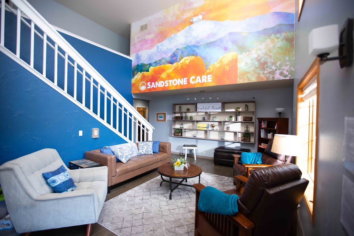 Living space with signage, wall art, seating, and a bookshelf.