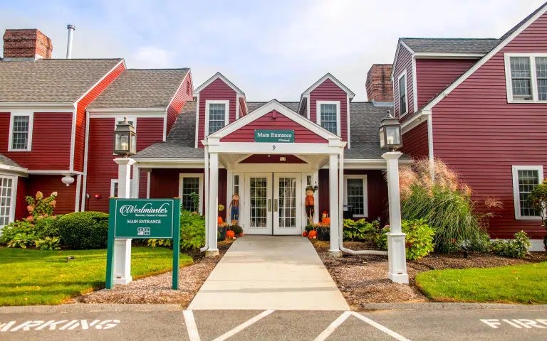 Entrance walkway with signage and parking.