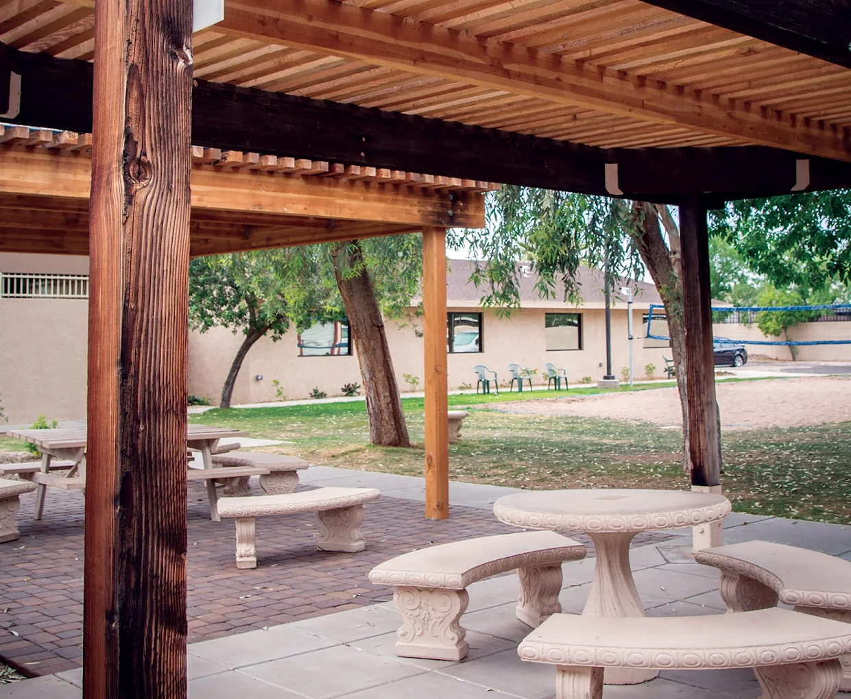 Covered outdoor seating area with stone tables and benches