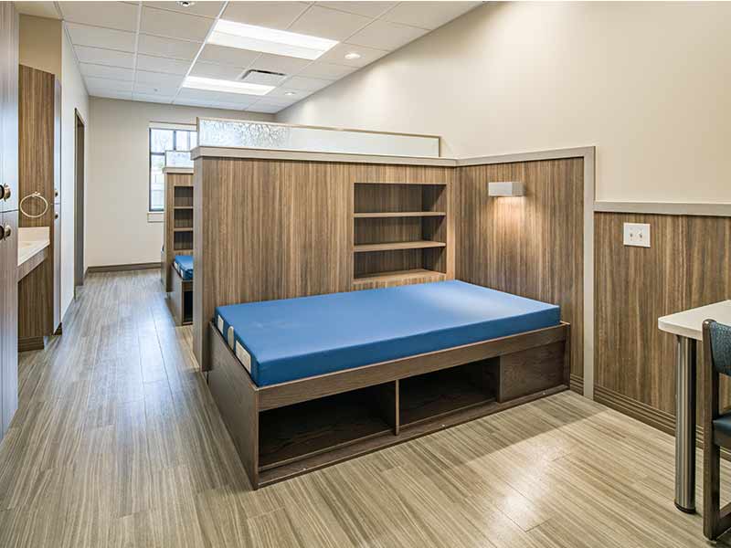 Modern residential patient room with beds and storage inside treatment center