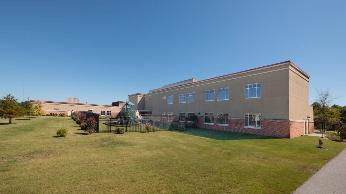 Side view of facility with landscaped grounds and lawn