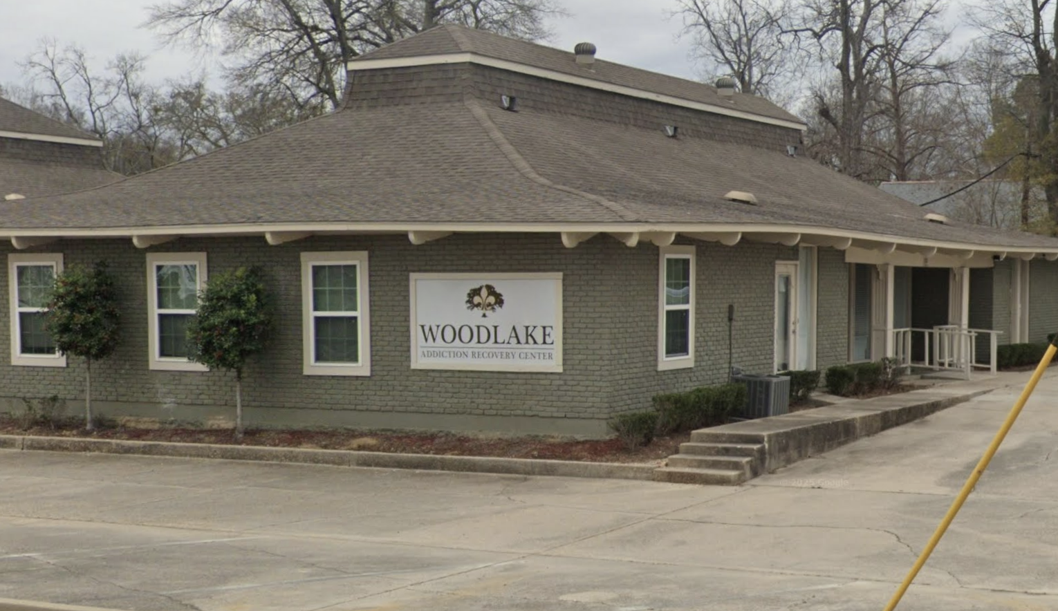 Exterior of Woodlake Addiction Recovery Center showing the facility building, entrance, and Woodlake signage