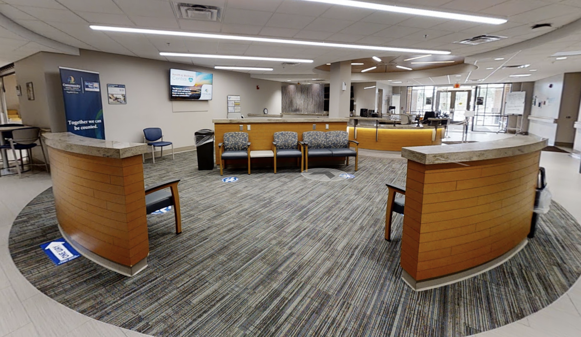 Spacious reception area with wooden desks and carpeted flooring