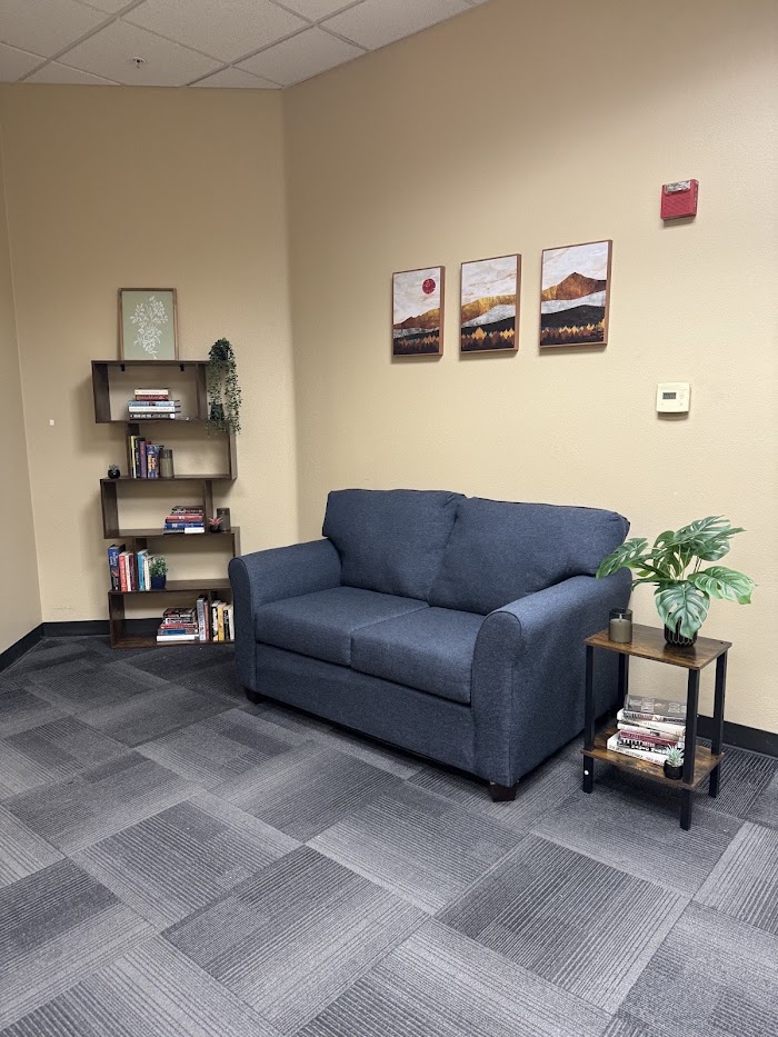 Blue sofa with bookshelf and plant in a counseling waiting area