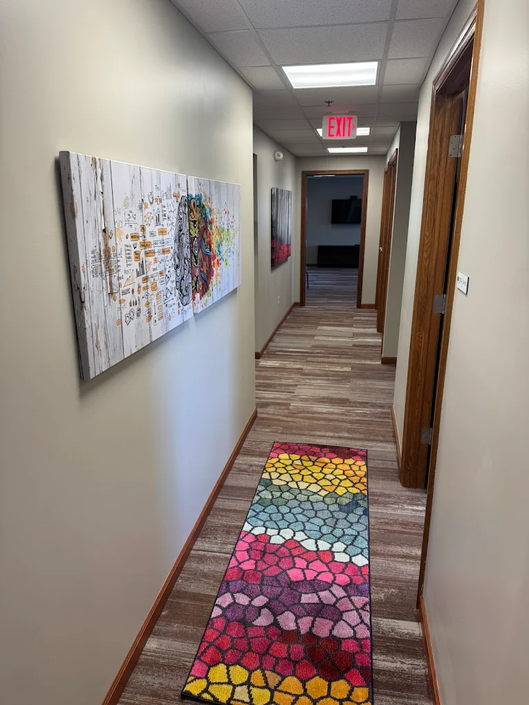 Hallway with colorful runner rug and wall artwork