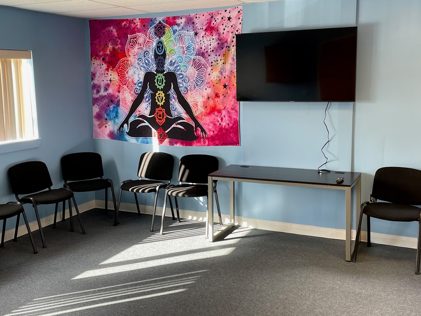 Group therapy room with chairs arranged in a circle and a TV.