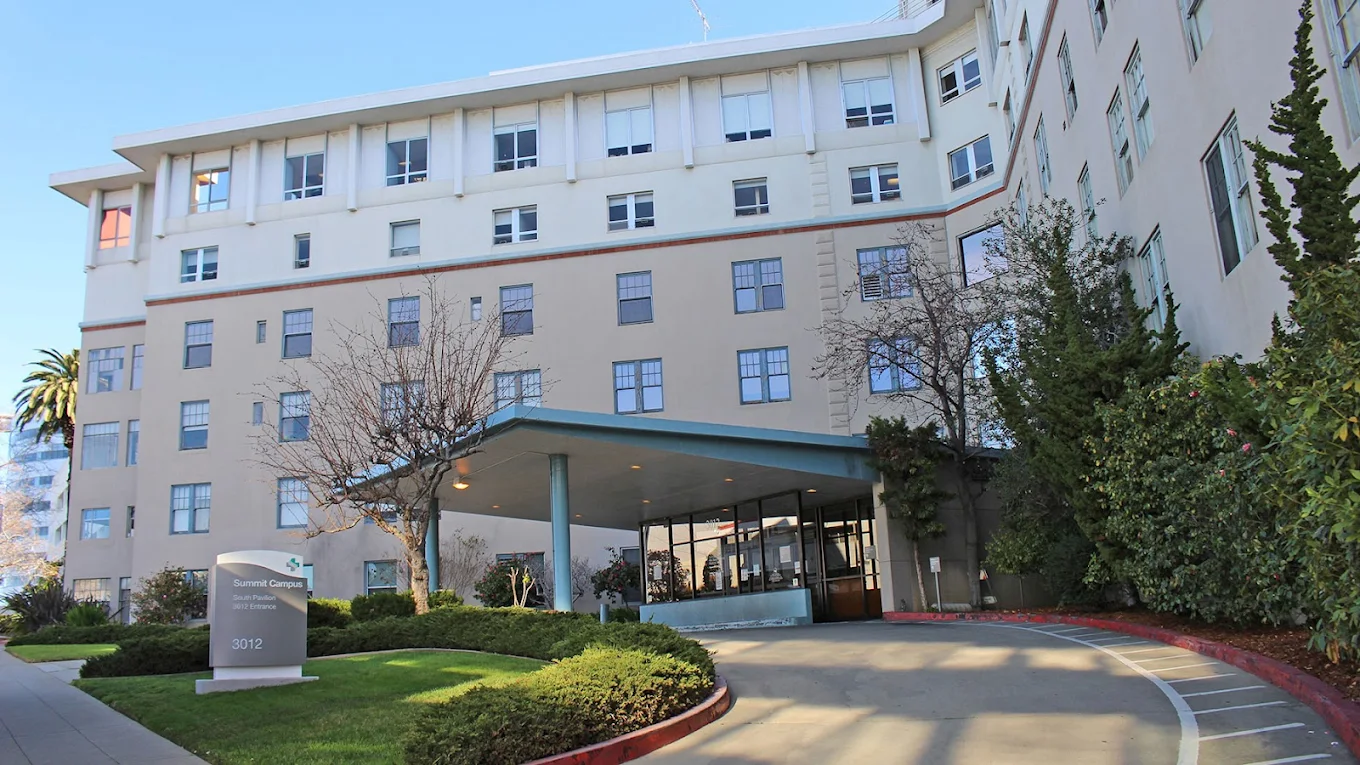 Multi-story hospital building with glass entry and driveway