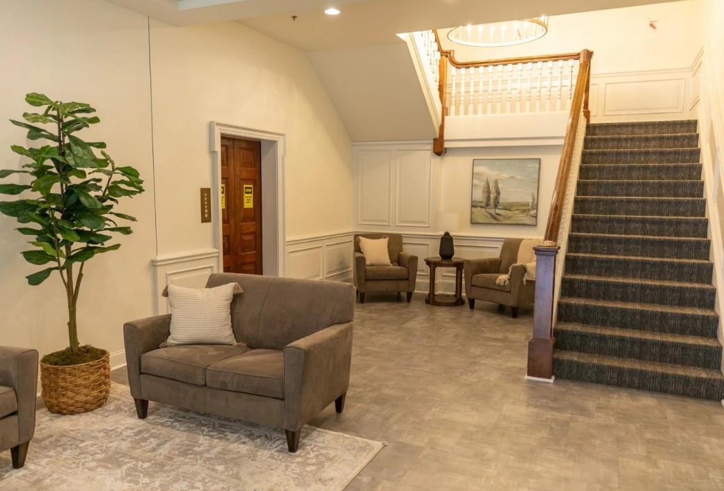 Lobby seating area with chairs and staircase