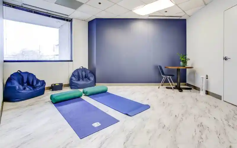 Yoga room with blue mats, bean bags, and navy accent wall