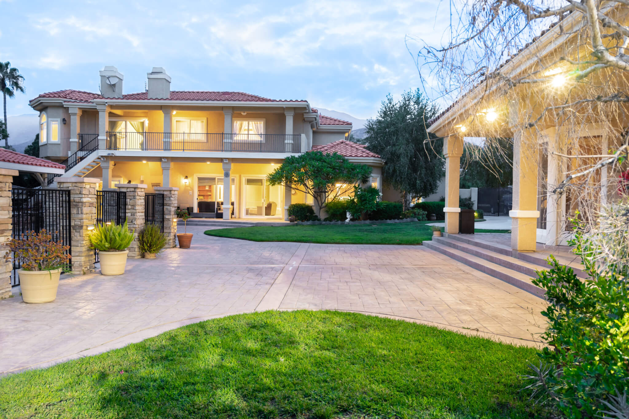 Courtyard and walkway leading to a lit two-story rehab home