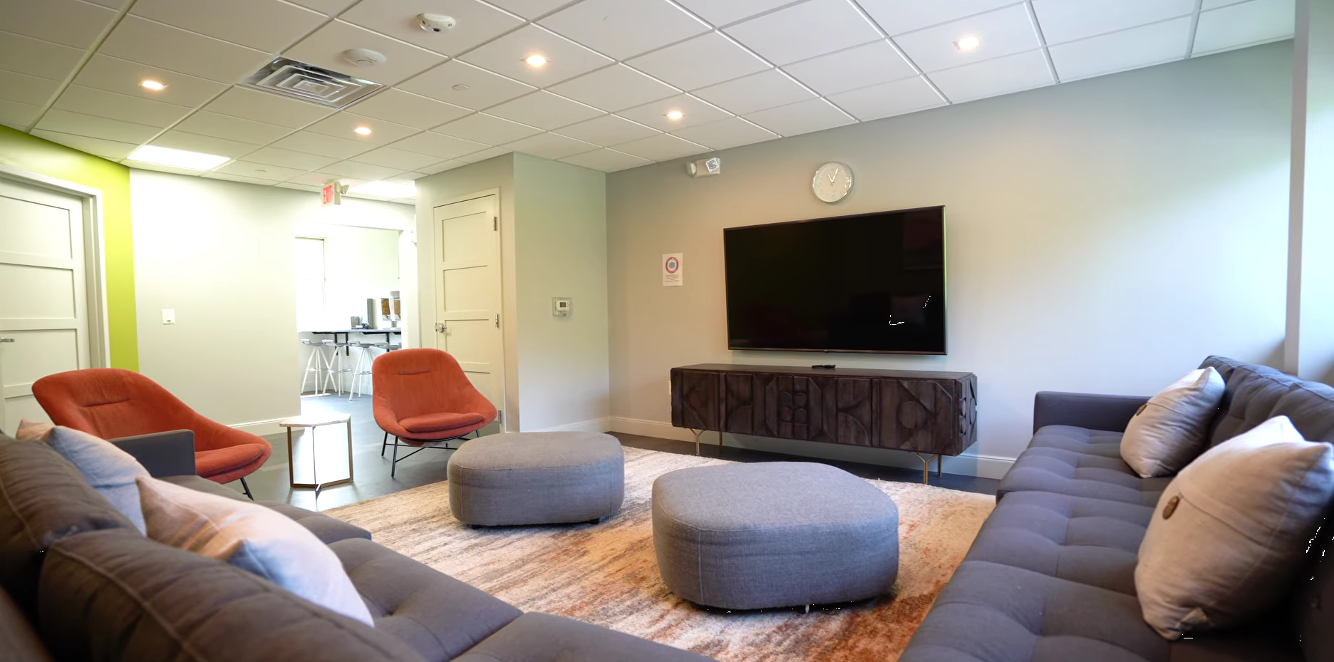 Group lounge with sofas, chairs, and large TV