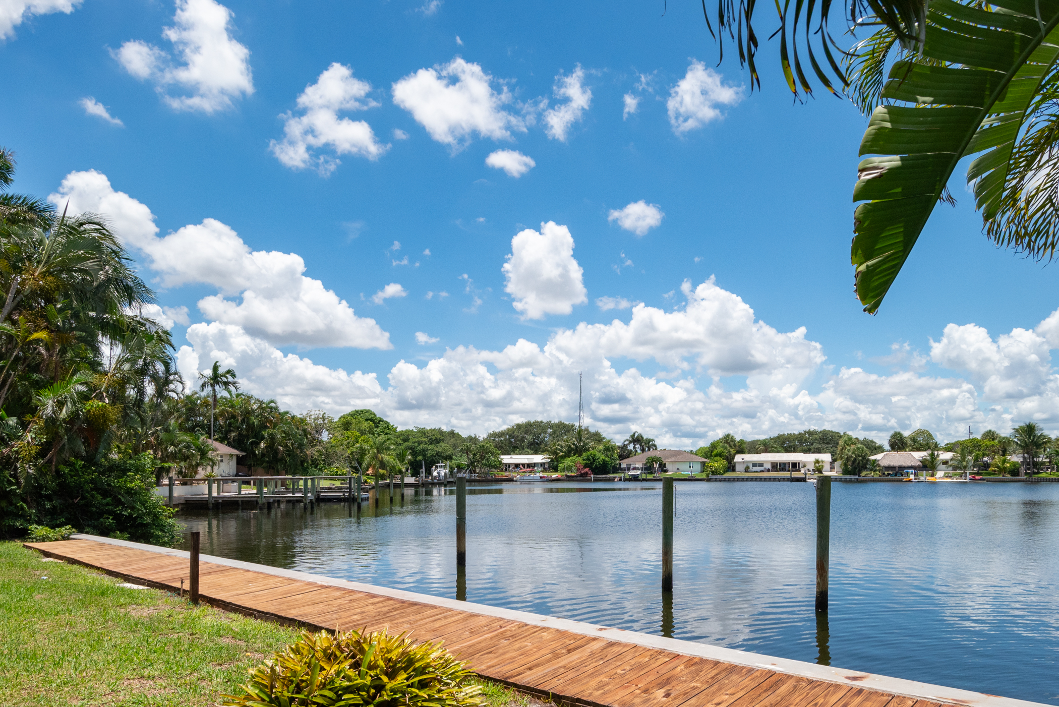 View of lakefront and wooden dock under blue sky