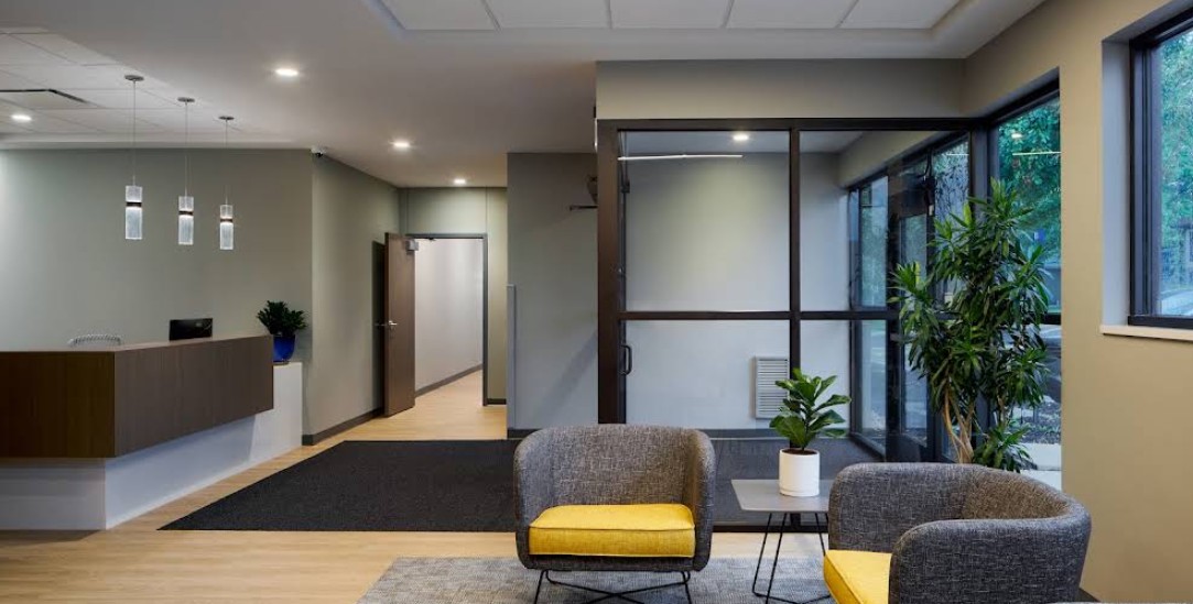 Modern lobby with reception desk, seating, and large windows