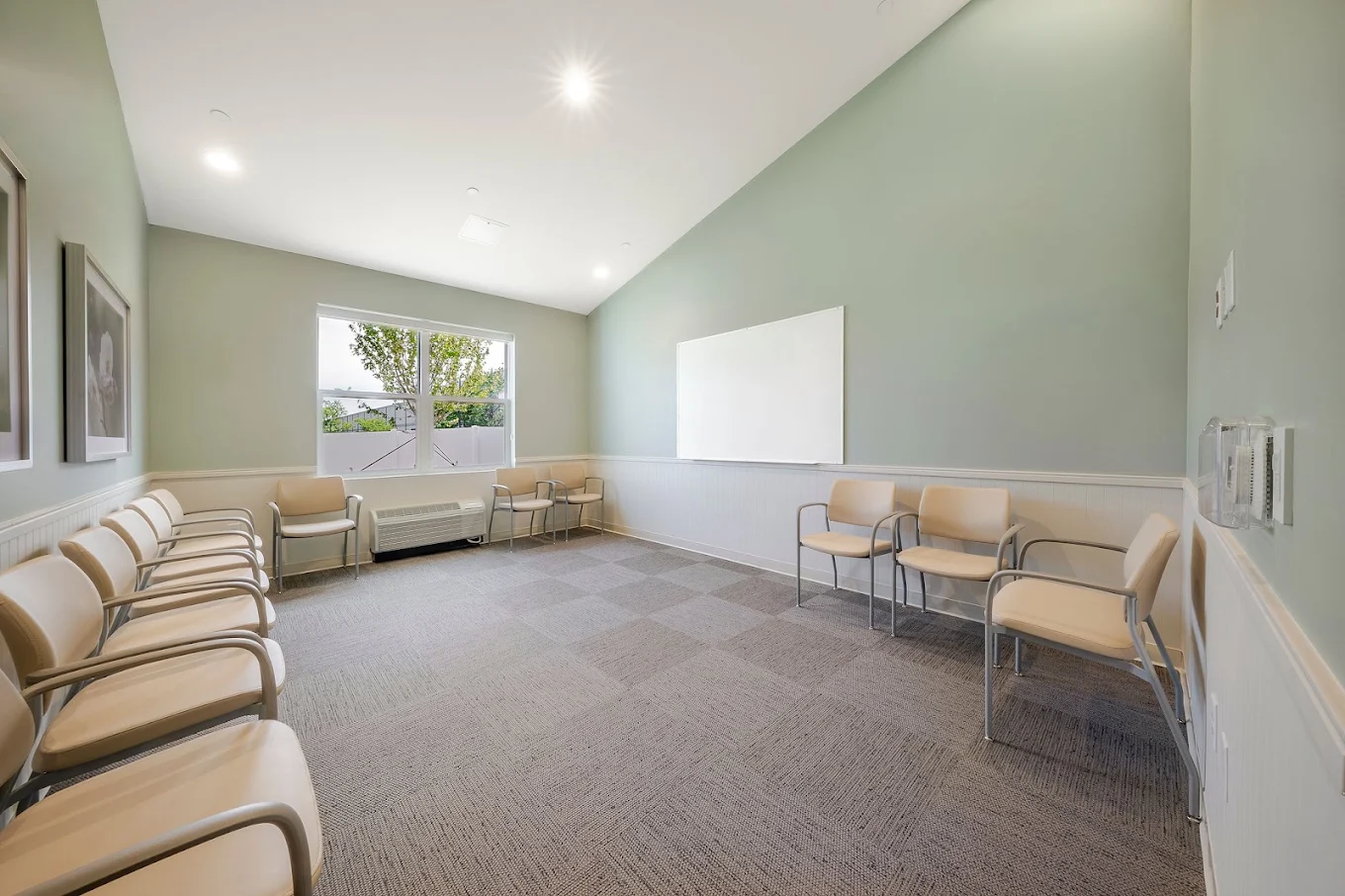 Group meeting room with chairs arranged along the walls and a large whiteboard