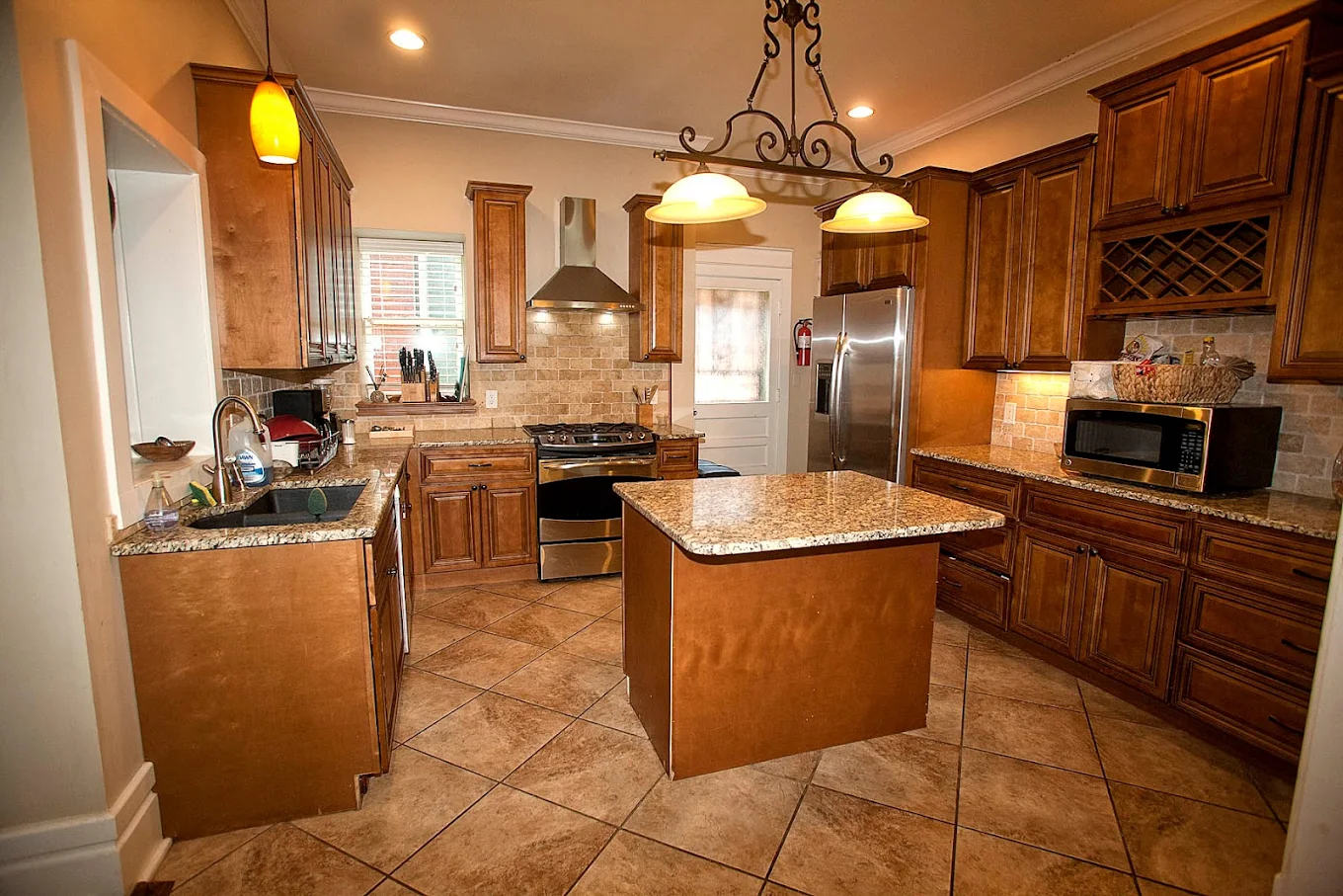 Spacious kitchen with granite countertops, wooden cabinetry, and stainless steel appliances