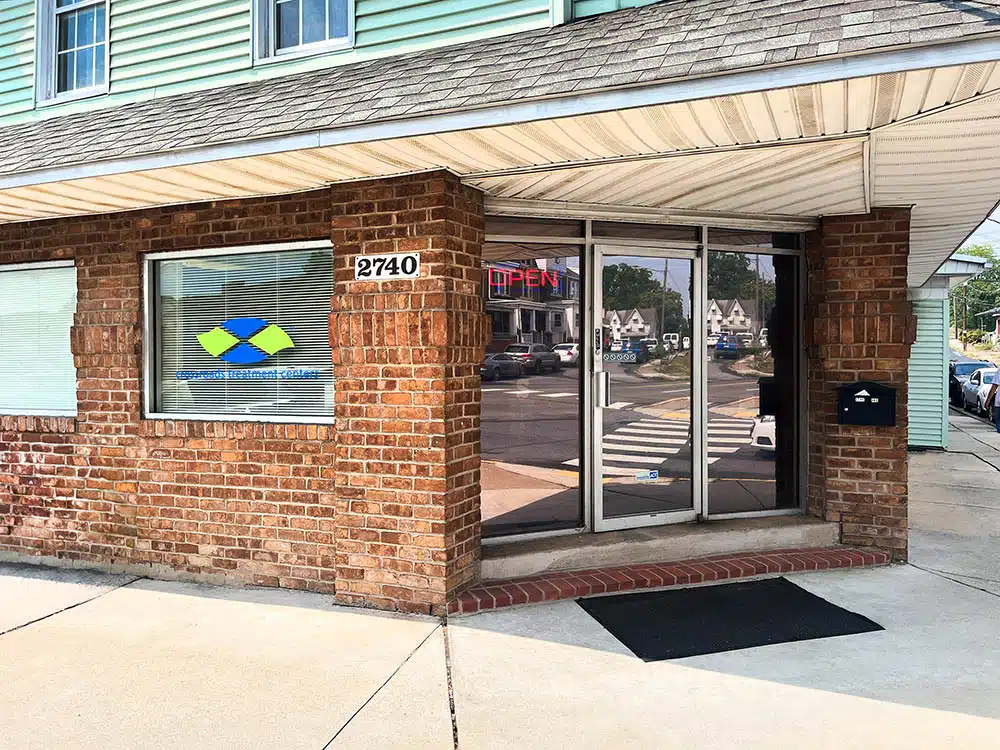 Brick building entrance with glass door and Crossroads sign