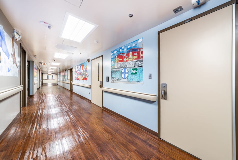 Bright hallway with murals and secured unit doors