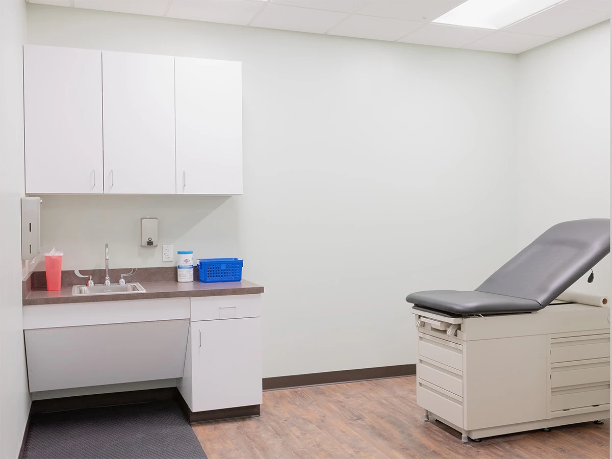 Medical exam room with exam table and sink