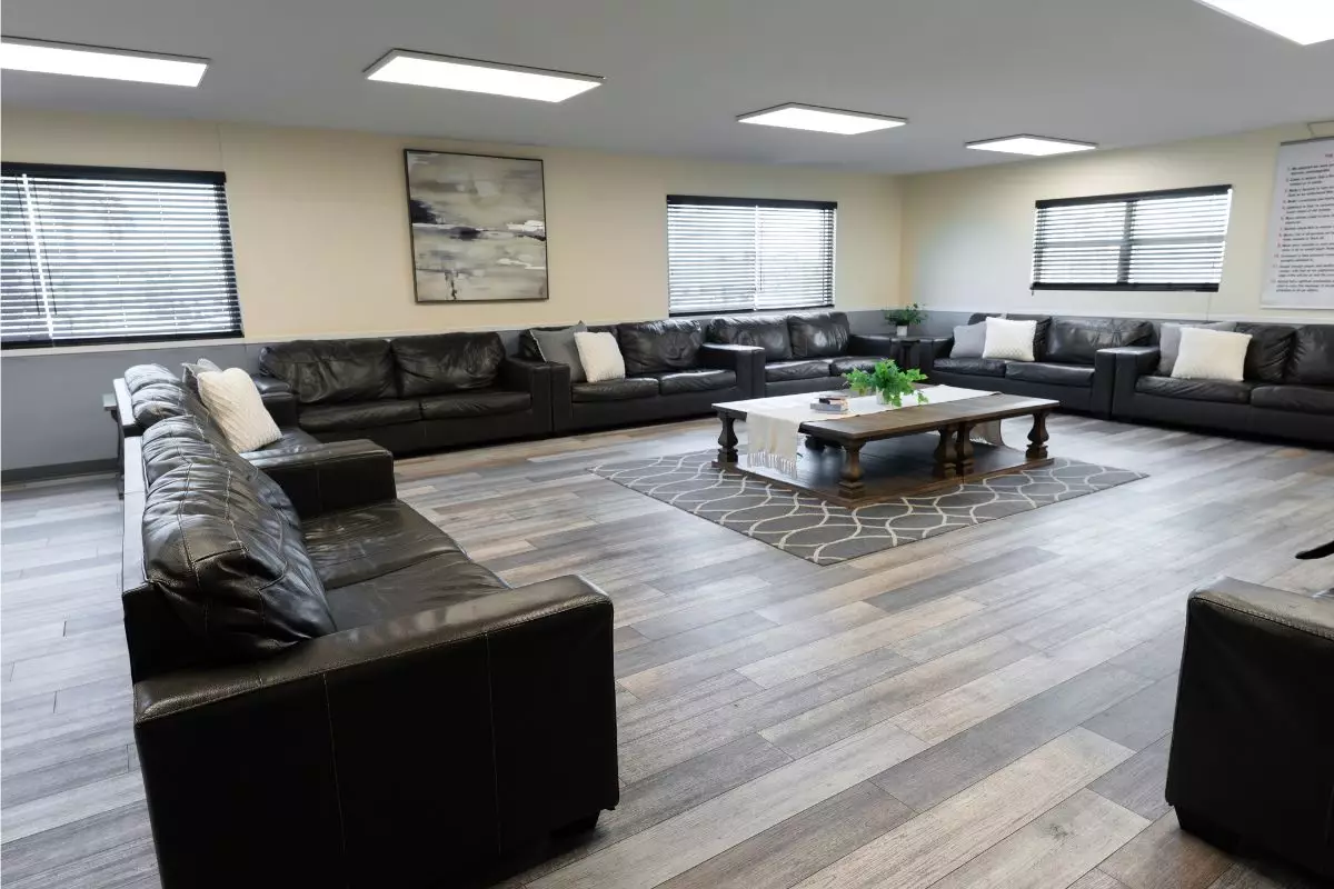 Spacious living room with black leather sofas and coffee table