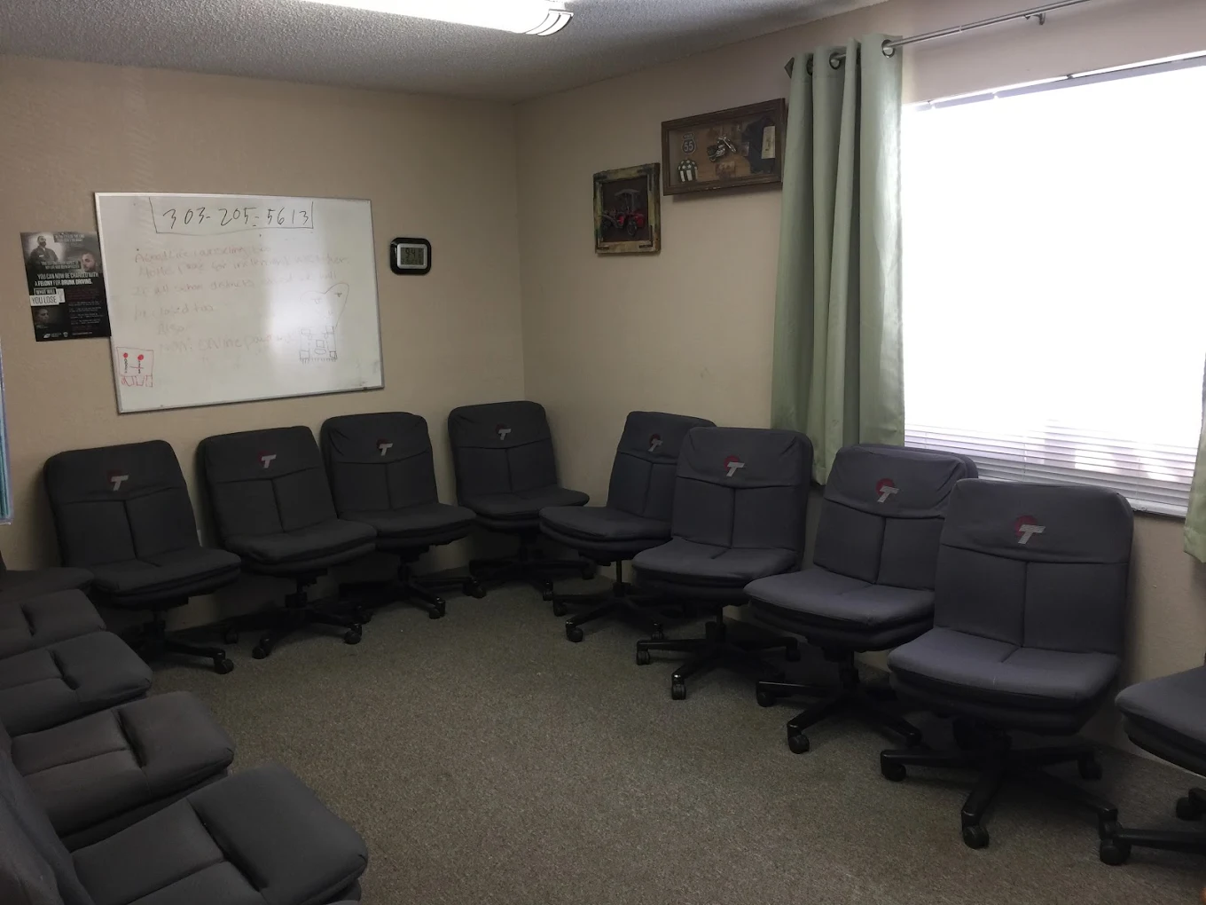 Meeting room with gray rolling chairs and whiteboard