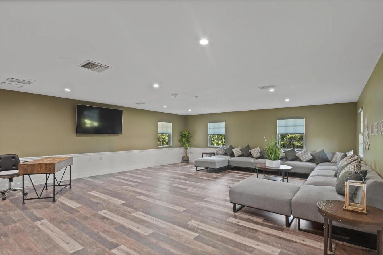 Large lounge with TV, sectional sofas, and desk