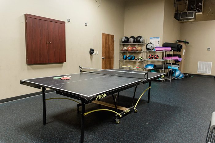 Ping pong table and gym equipment in indoor space
