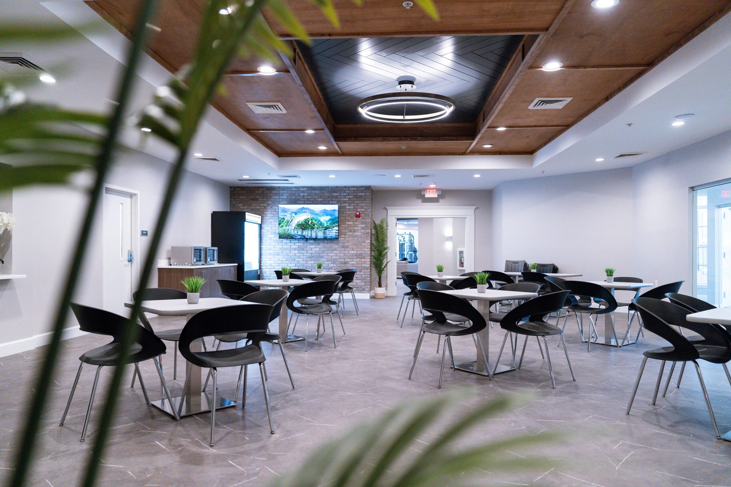 Cafeteria area with shared tables and seating, with snack bar.
