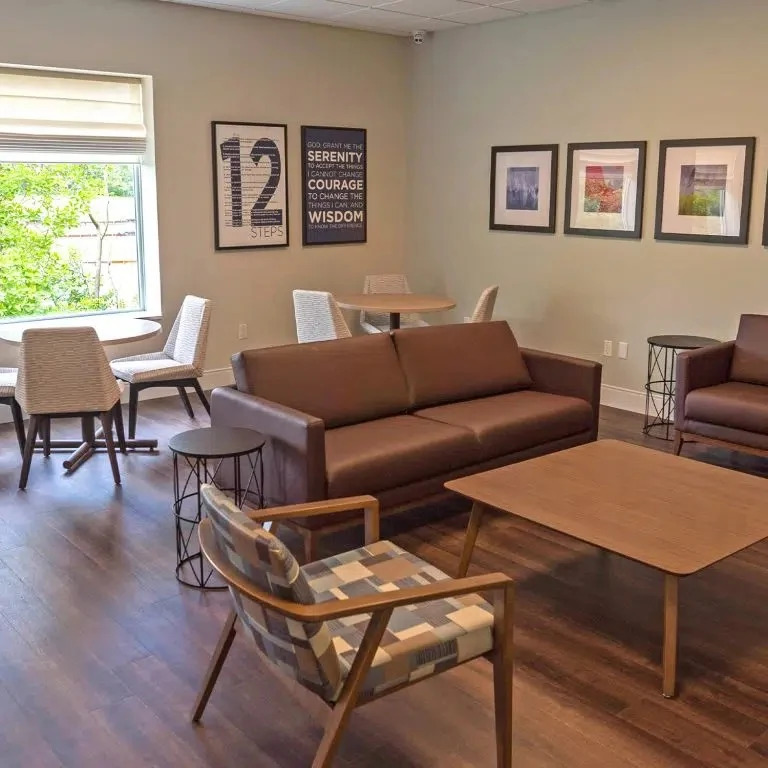 Lounge with brown couches and framed artwork on walls
