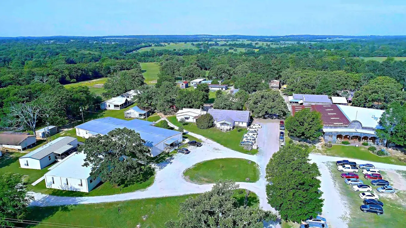 Aerial view showing buildings and wooded grounds of campus