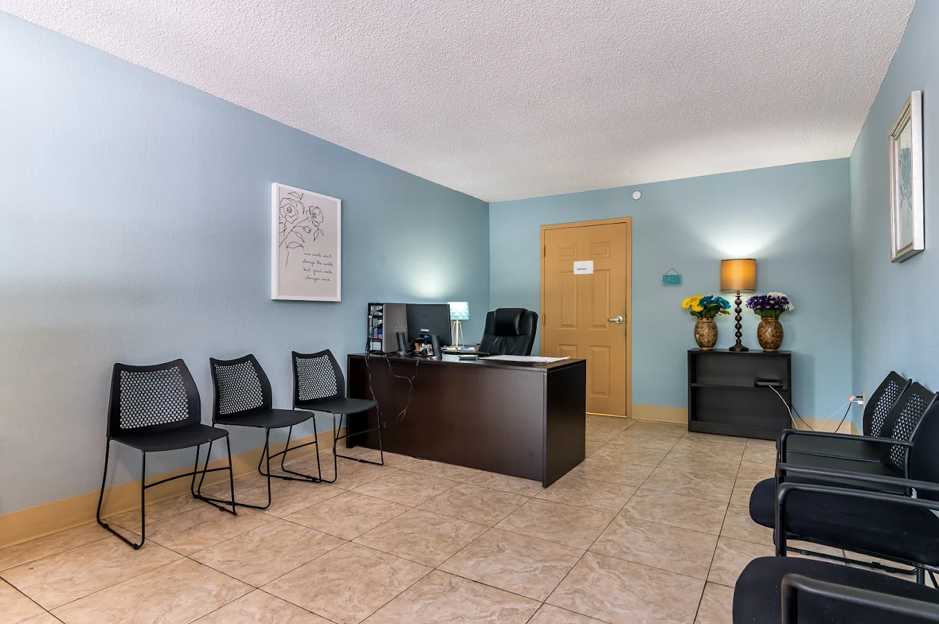Calm counseling office with desk and guest chairs.