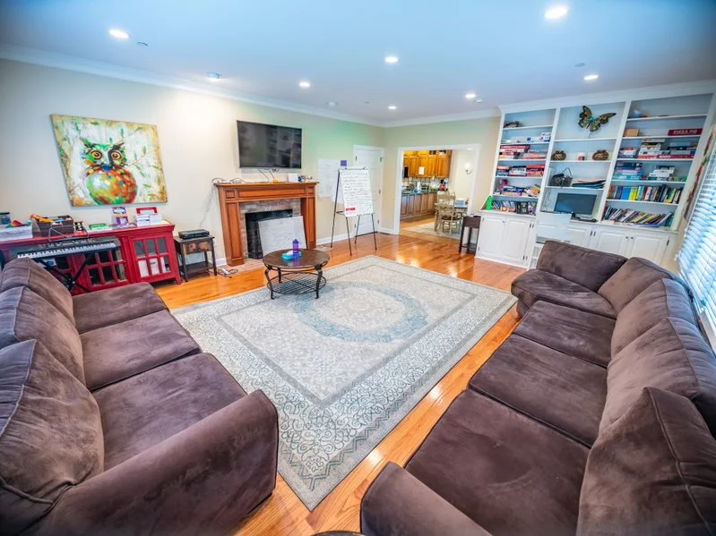 Spacious living room with sofas, fireplace, and bookshelves