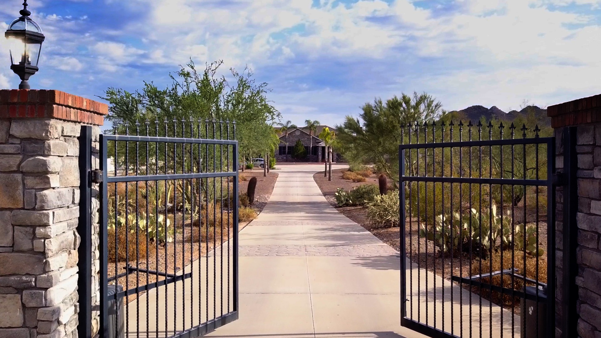 Open iron gates leading to a desert property and residence