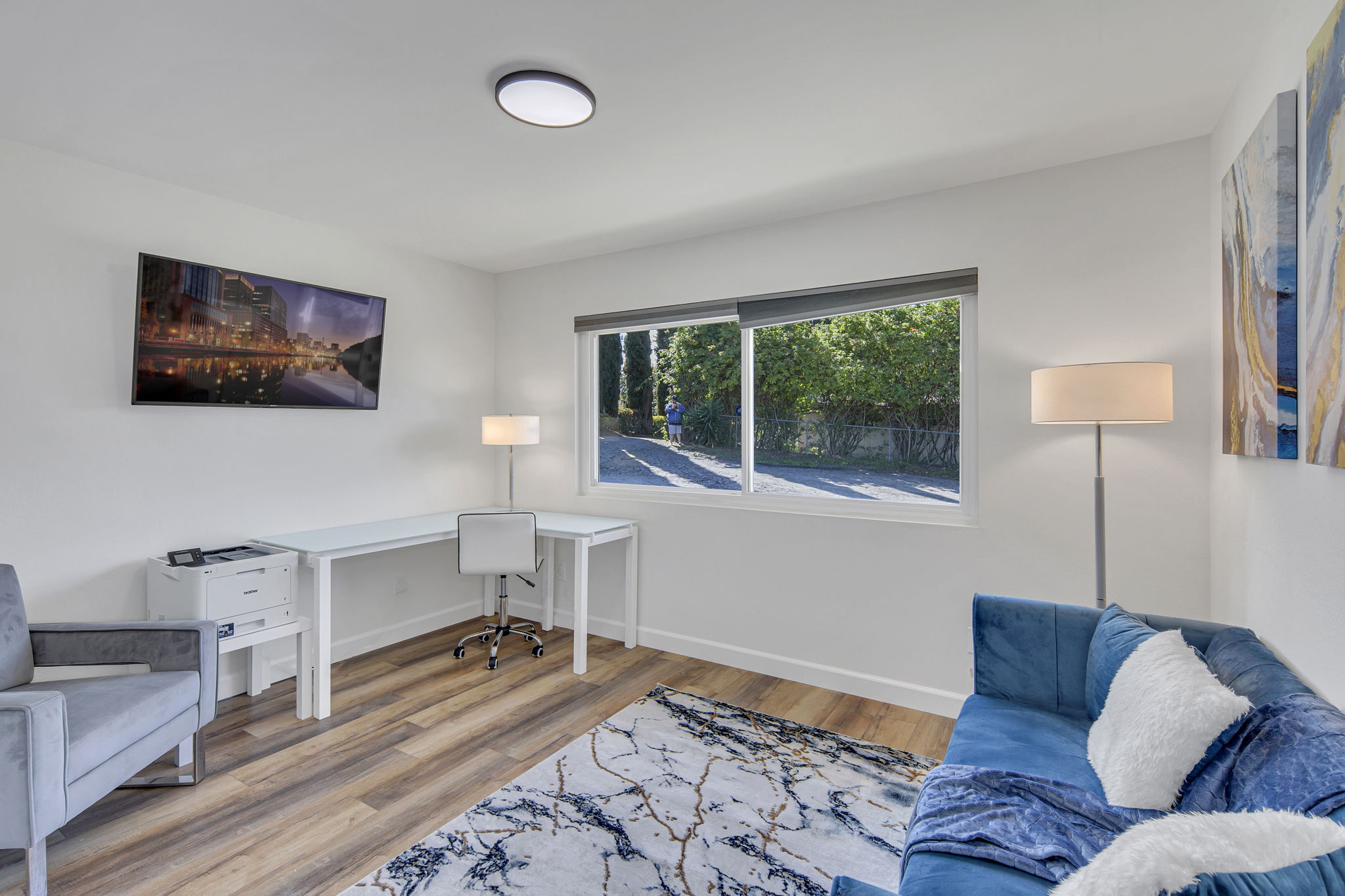Cozy office with desk, sofa, and large window