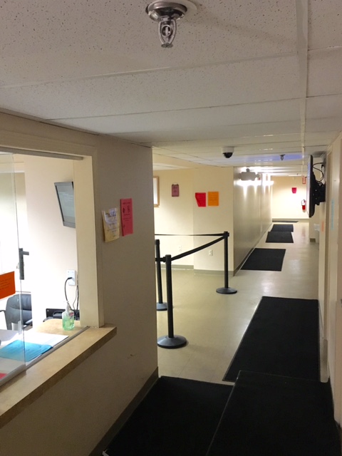 Hallway leading past a reception window.