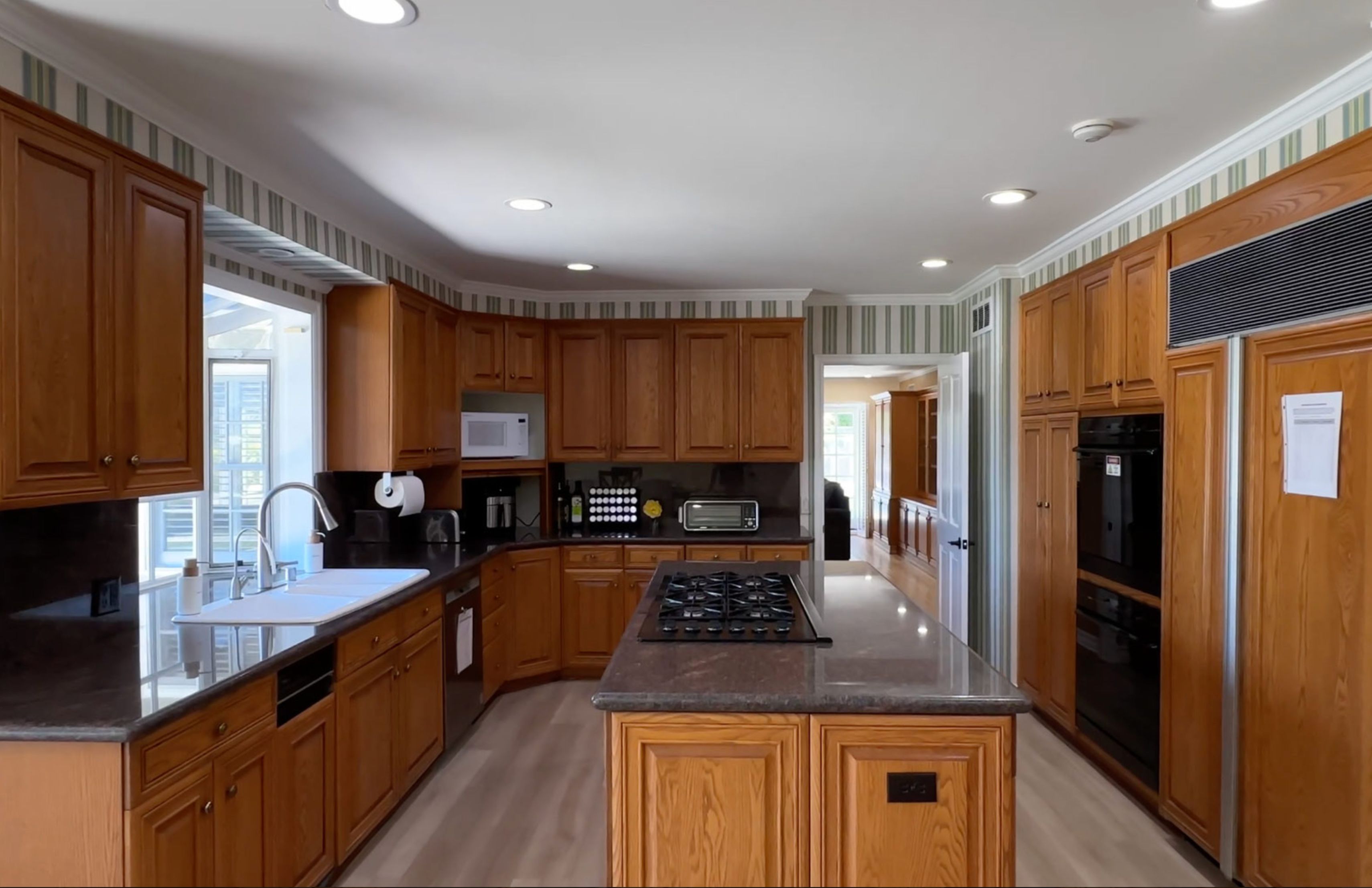 A spacious kitchen with wooden cabinetry and a center island.