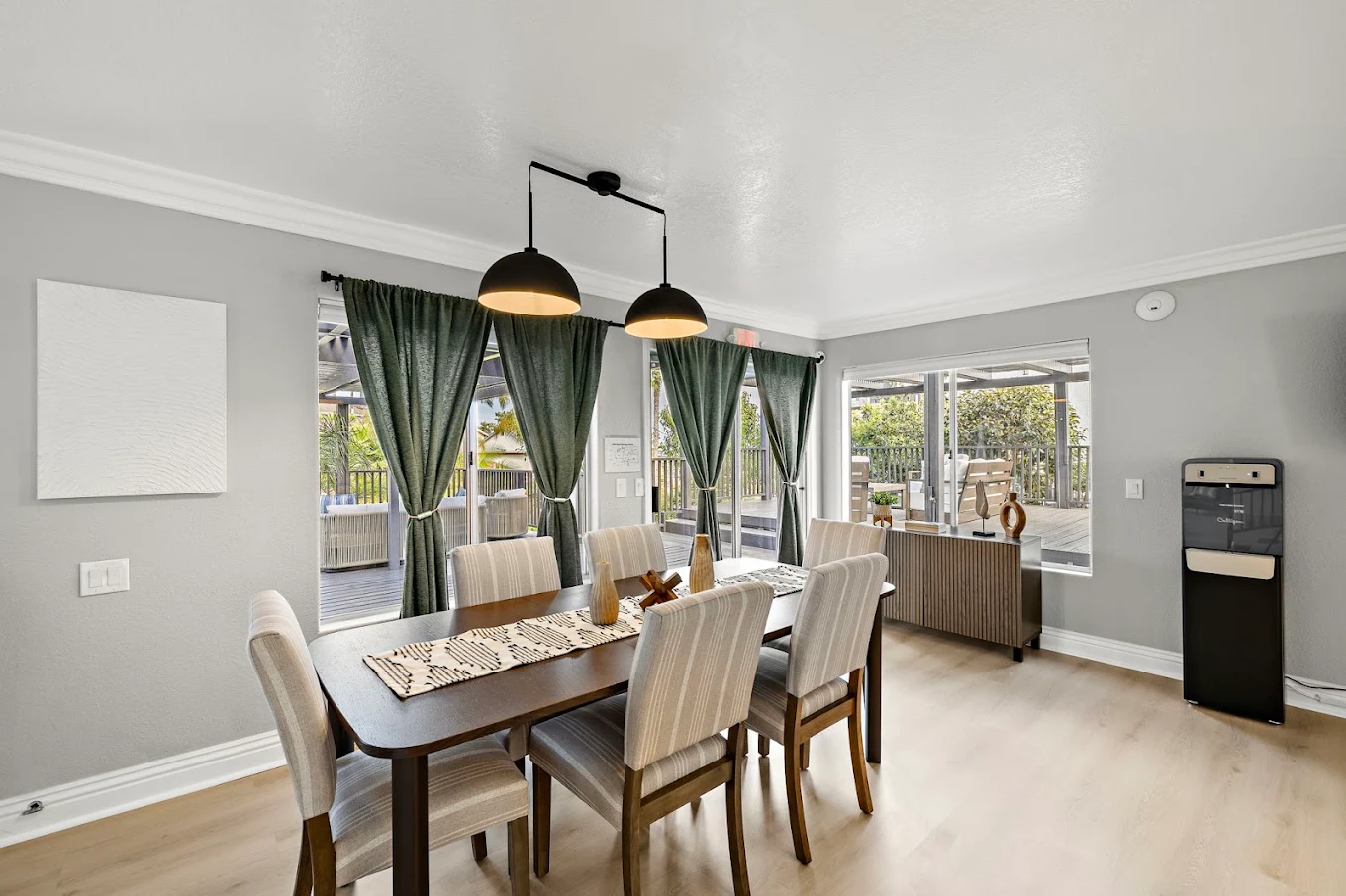 Dining area with large table, six chairs, and patio views