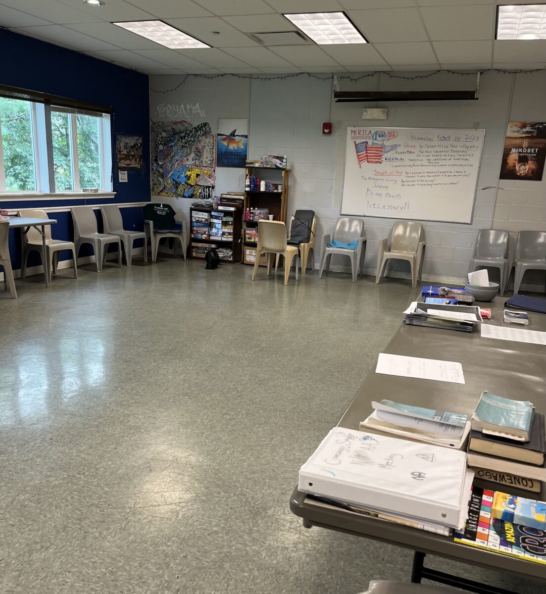 Rehab activity room with chairs, books, and whiteboard