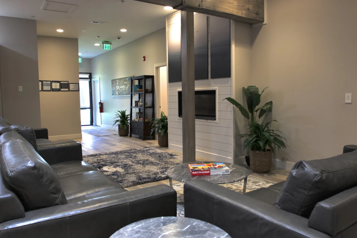 Resident lounge with leather sofas, a fireplace, and indoor plants at Brighton House